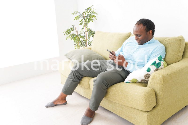 自宅でスマホを使う黒人のビジネスマン