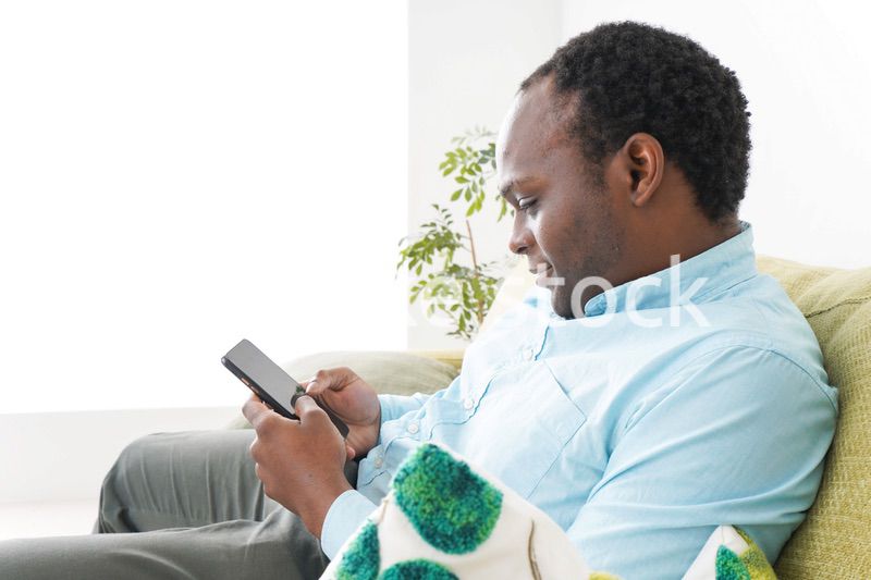 自宅でスマホを使う黒人のビジネスマン