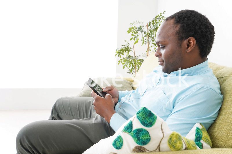 自宅でスマホを使う黒人のビジネスマン