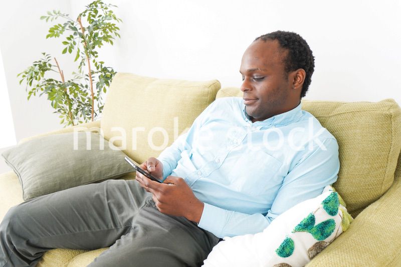 自宅でスマホを使う黒人のビジネスマン