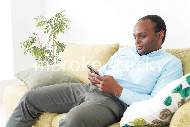 自宅でスマホを使う黒人のビジネスマン