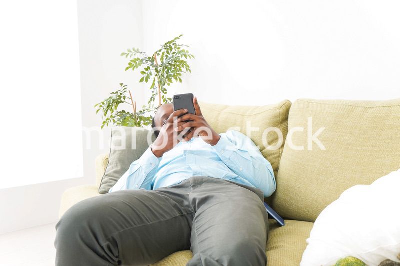 自宅でスマホを使う黒人のビジネスマン