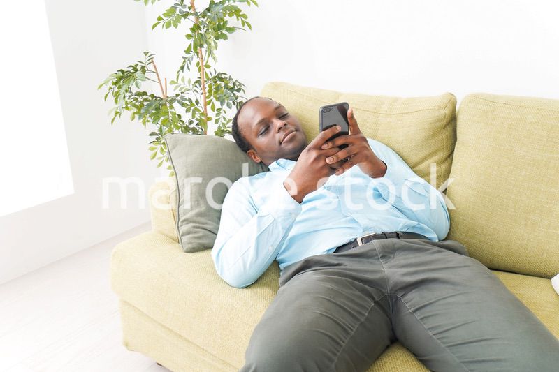 自宅でスマホを使う黒人のビジネスマン