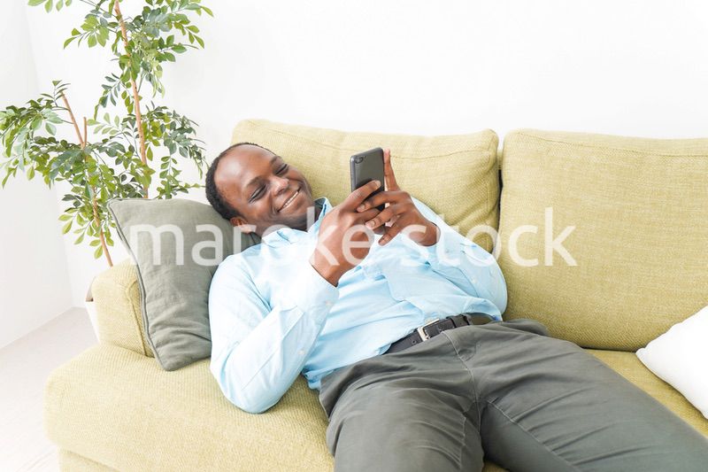 自宅でスマホを使う黒人のビジネスマン