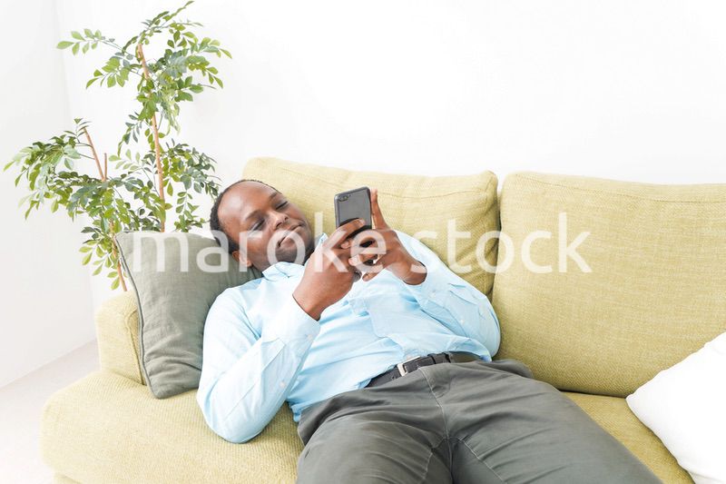 自宅でスマホを使う黒人のビジネスマン