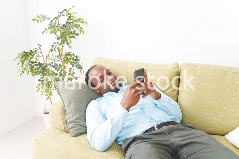 自宅でスマホを使う黒人のビジネスマン