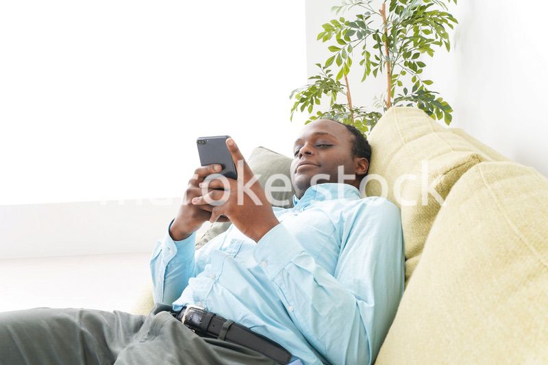 自宅でスマホを使う黒人のビジネスマン