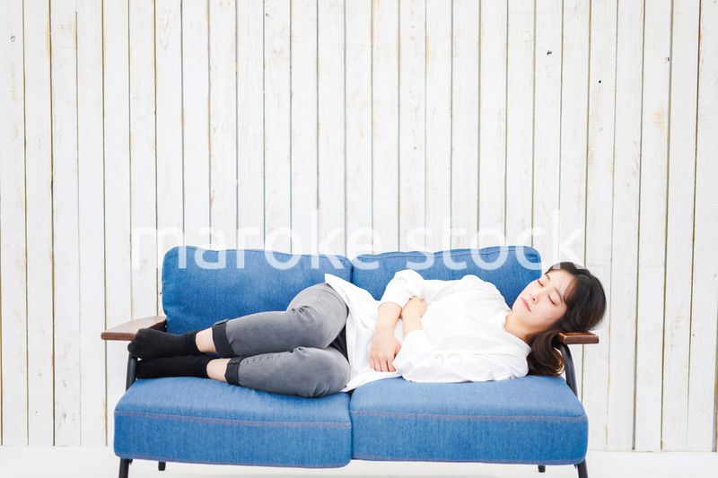 部屋で昼寝をする若い女性