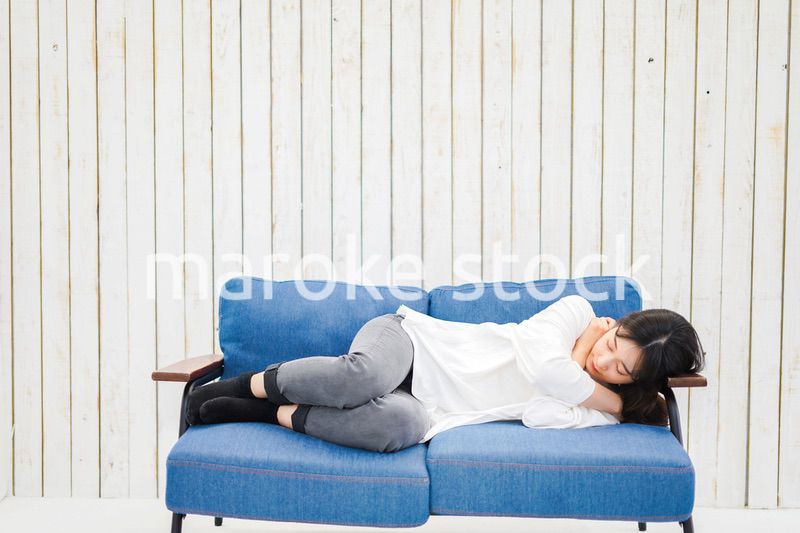 部屋で昼寝をする若い女性