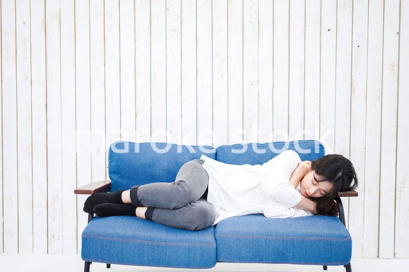 部屋で昼寝をする若い女性
