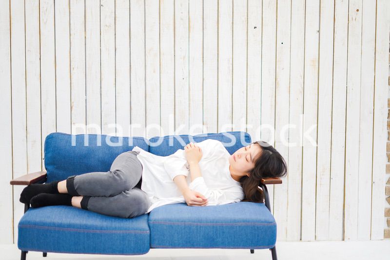 部屋で昼寝をする若い女性