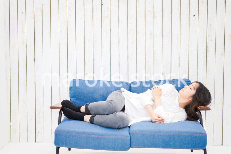 部屋で昼寝をする若い女性