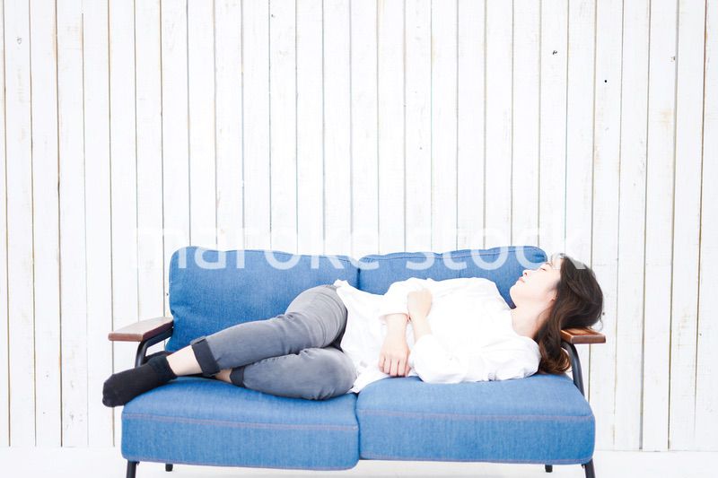 部屋で昼寝をする若い女性