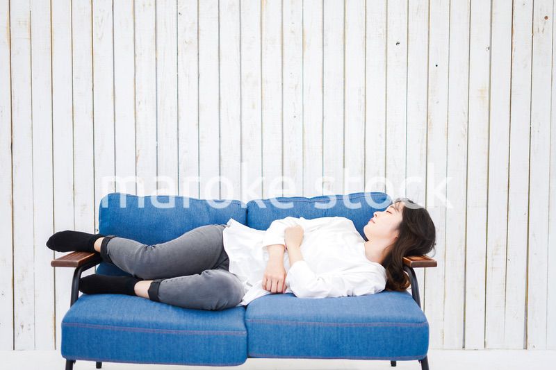 部屋で昼寝をする若い女性