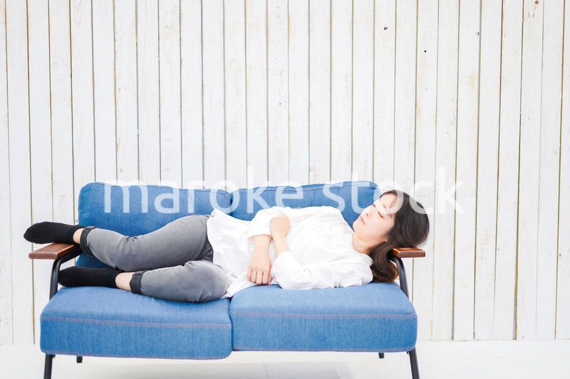 部屋で昼寝をする若い女性