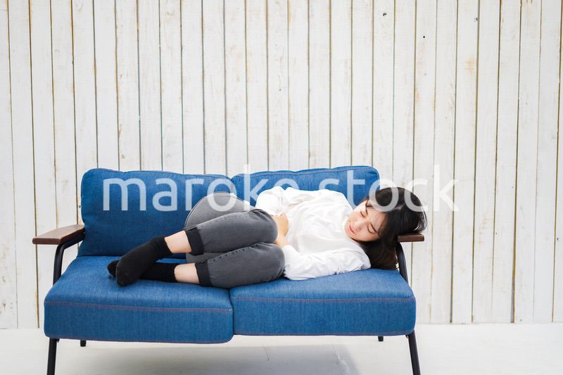 部屋で昼寝をする若い女性