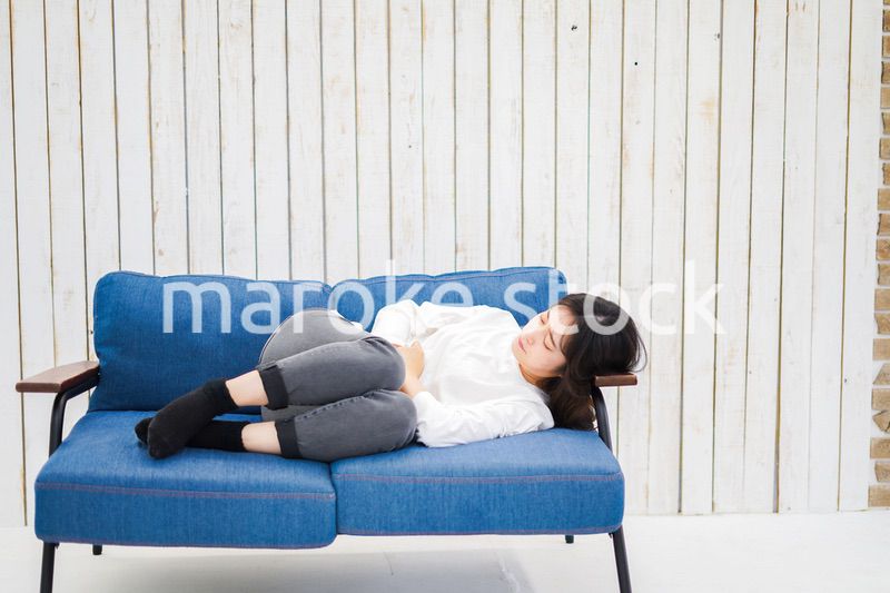 部屋で昼寝をする若い女性