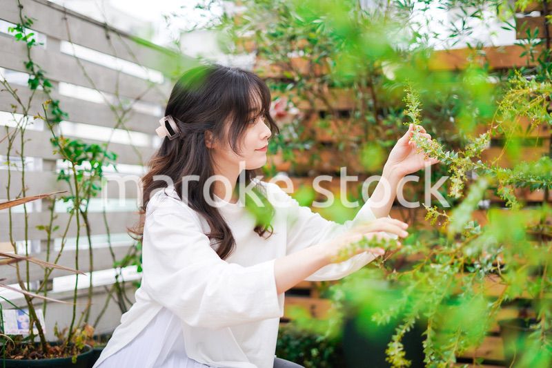 庭でガーデニングをする若い女性