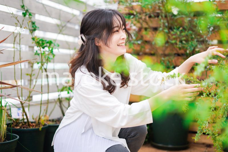 庭でガーデニングをする若い女性