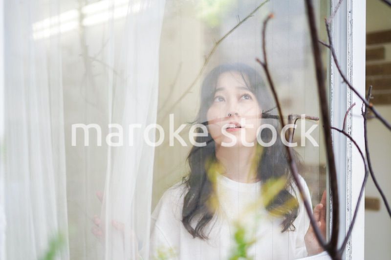 外の天気を確認する若い女性