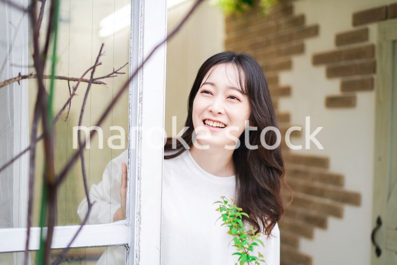 外の天気を確認する若い女性