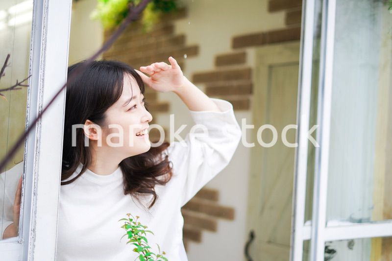 外の天気を確認する若い女性