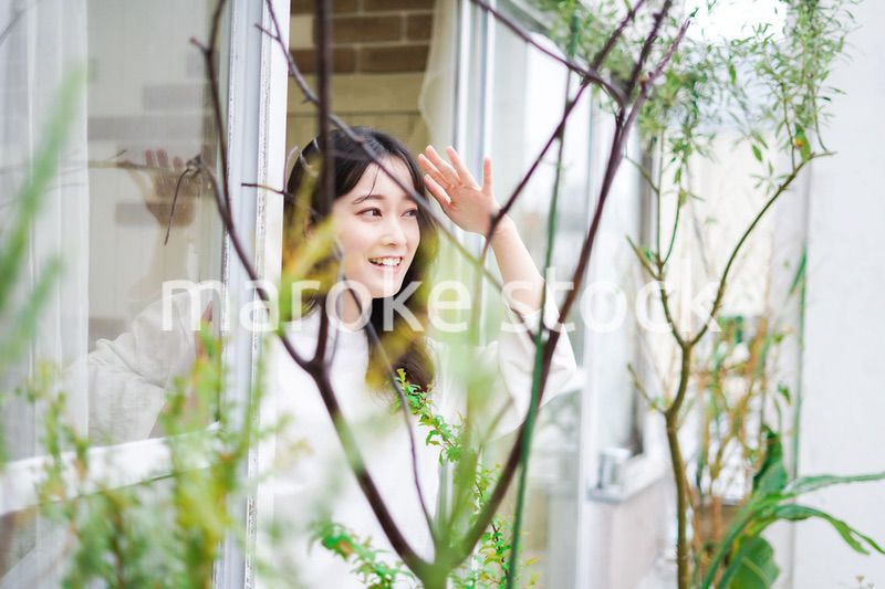 外の天気を確認する若い女性