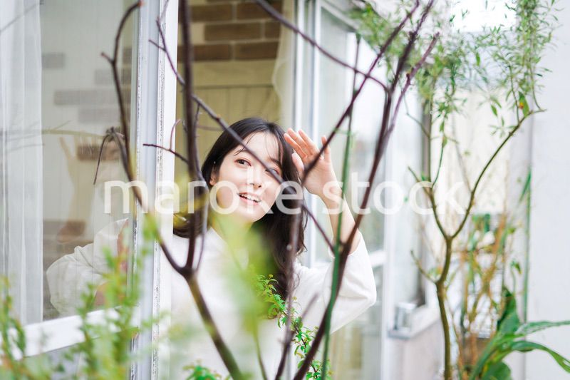 外の天気を確認する若い女性