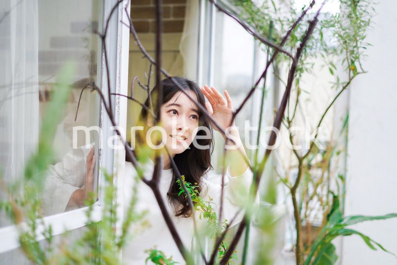 外の天気を確認する若い女性