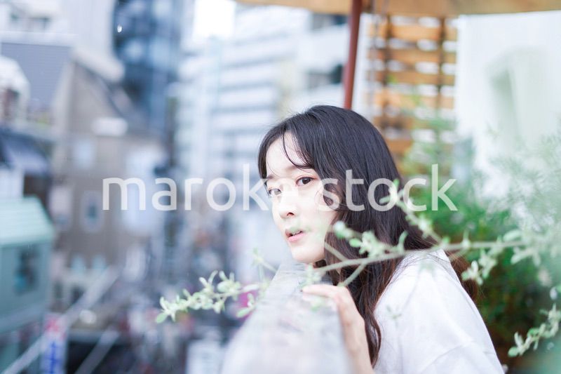 外の天気を確認する若い女性