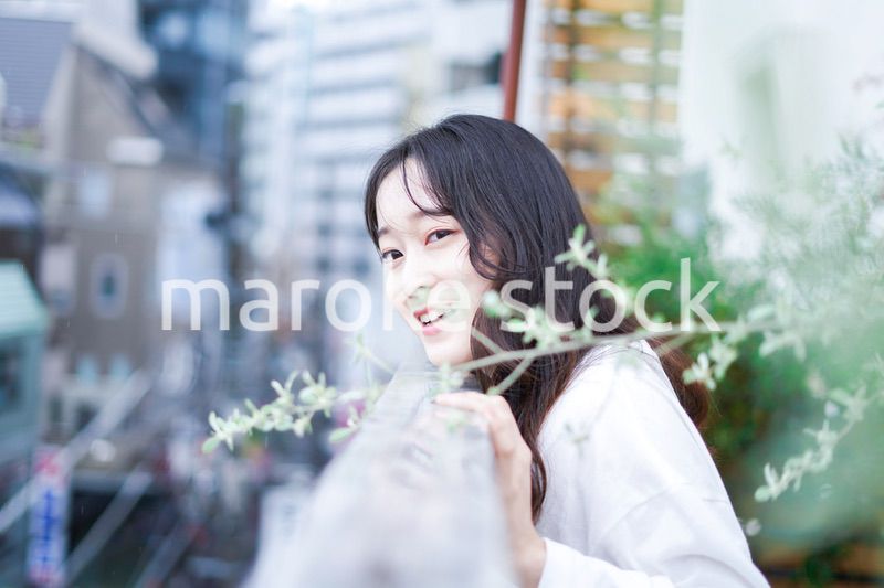 外の天気を確認する若い女性