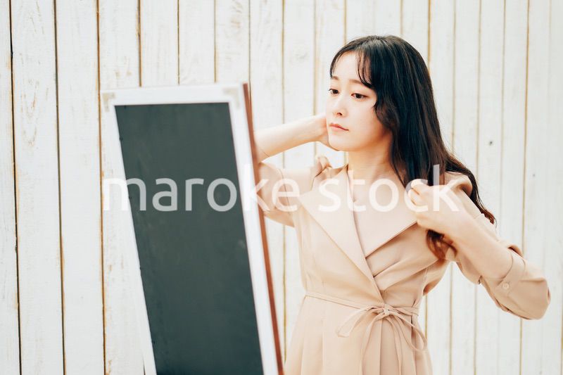 服のフィッティングをする若い女性