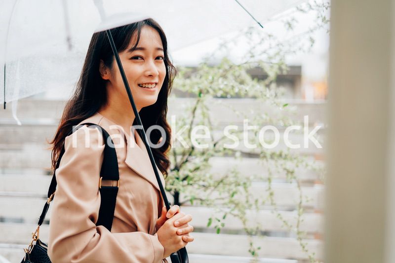 雨が降る中出勤する若い女性