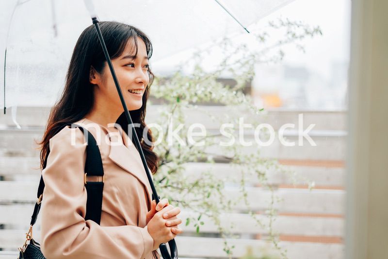 雨が降る中出勤する若い女性