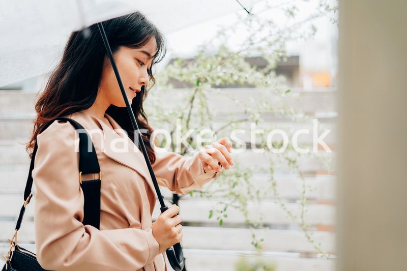 雨が降る中出勤する若い女性