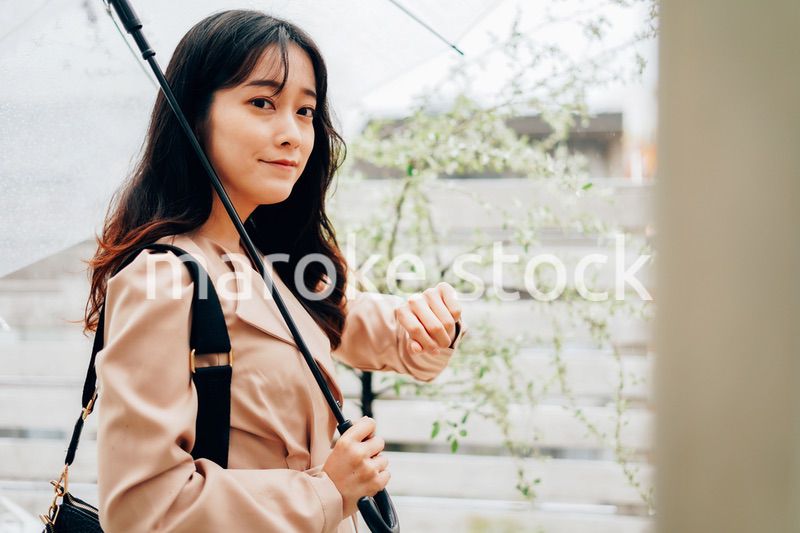 雨が降る中出勤する若い女性