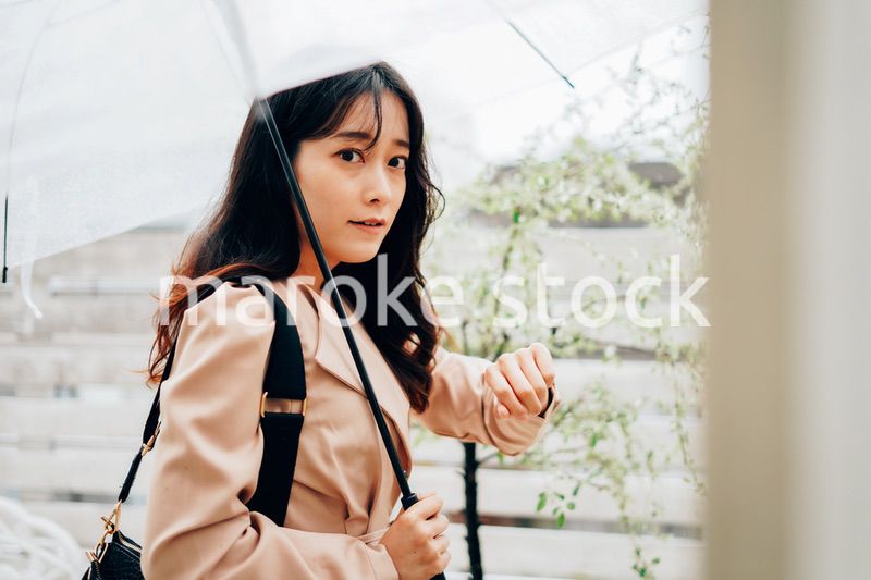 雨が降る中出勤する若い女性