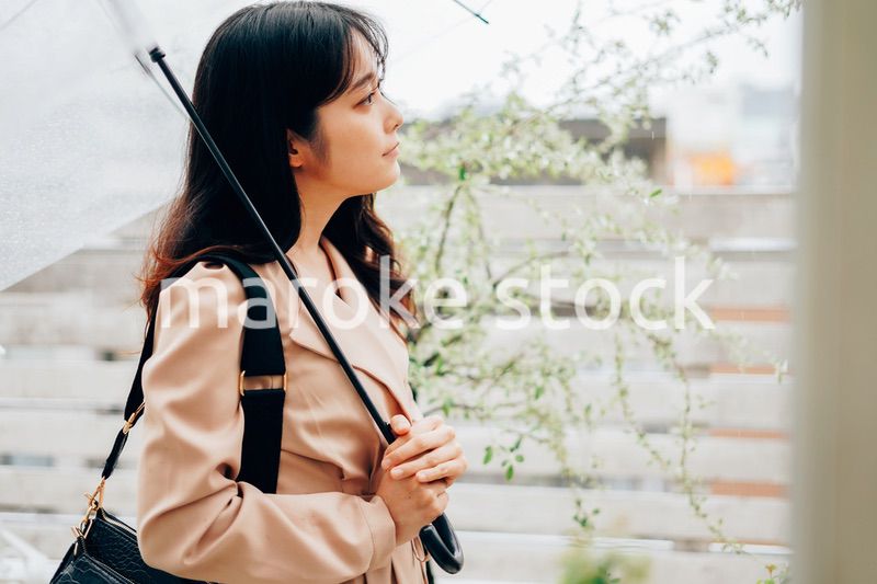 雨が降る中出勤する若い女性