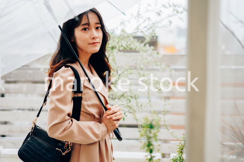 雨が降る中出勤する若い女性