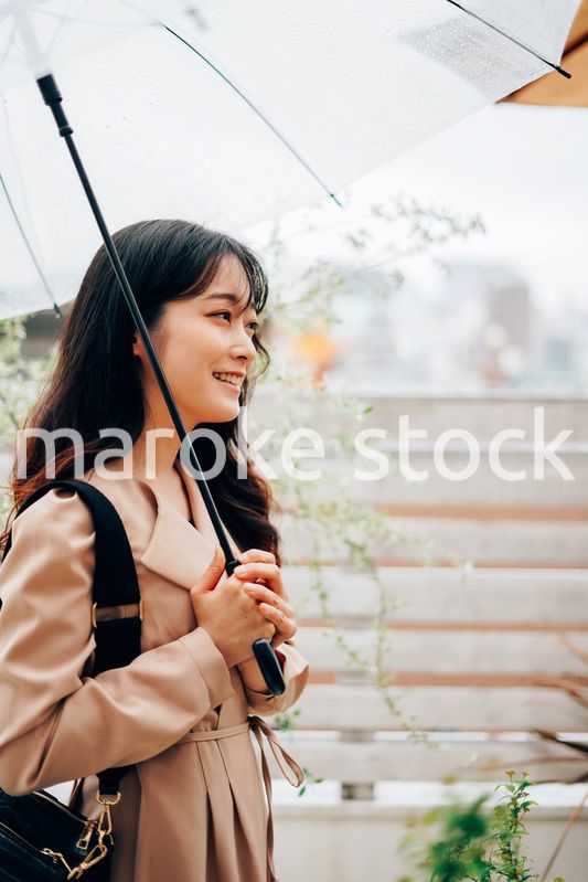 雨が降る中出勤する若い女性