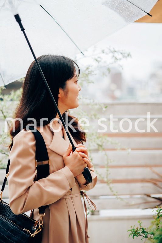雨が降る中出勤する若い女性