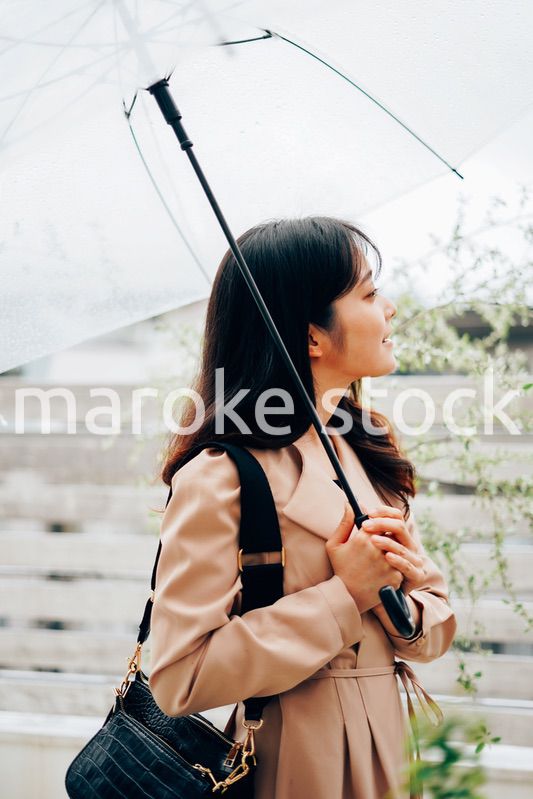雨が降る中出勤する若い女性