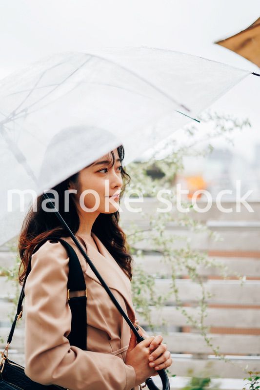 雨が降る中出勤する若い女性