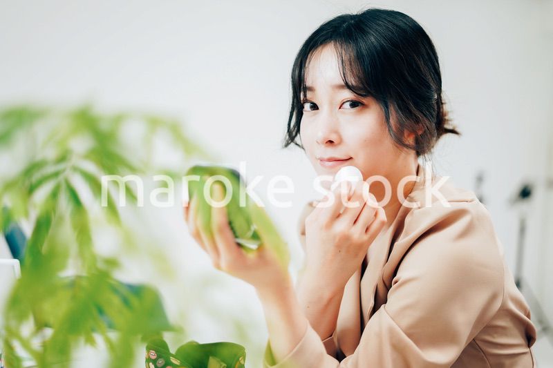 笑顔でメイクをする若い女性