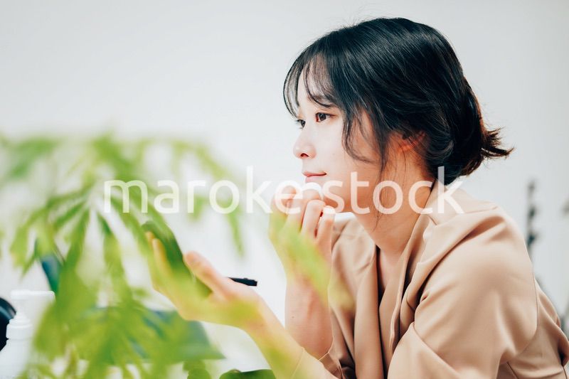 笑顔でメイクをする若い女性