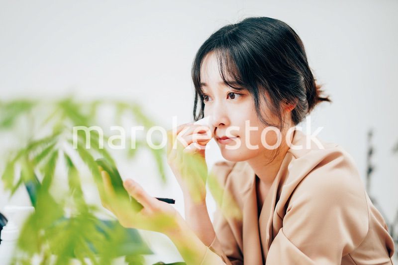 笑顔でメイクをする若い女性