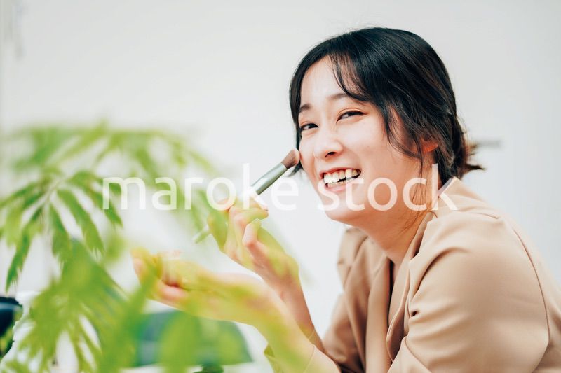 笑顔でメイクをする若い女性
