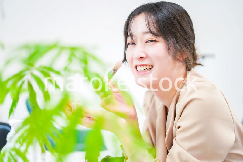 笑顔でメイクをする若い女性