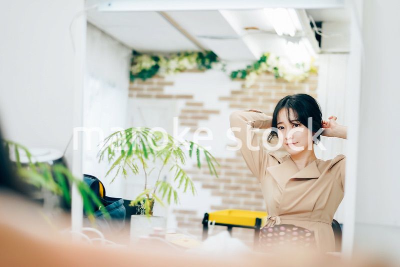 笑顔でメイクをする若い女性