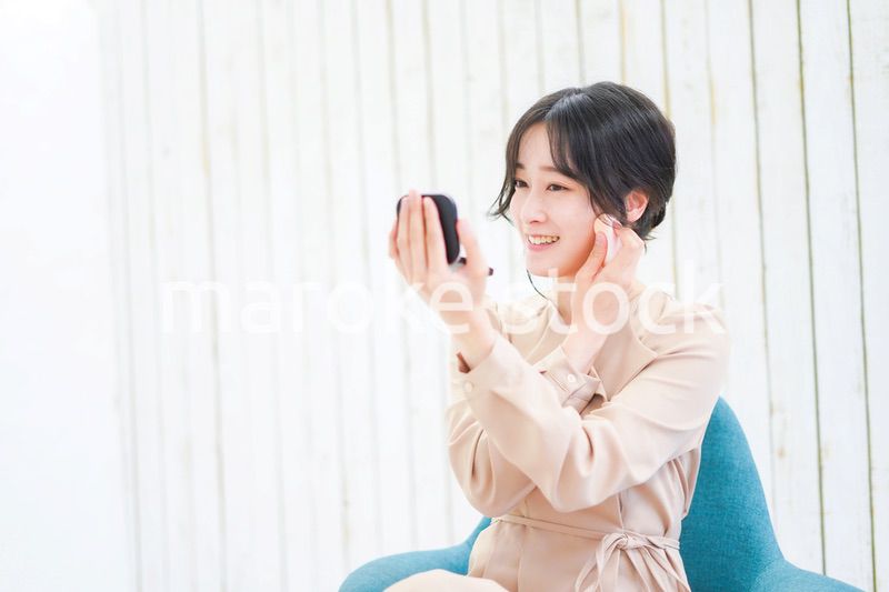 笑顔でメイクをする若い女性